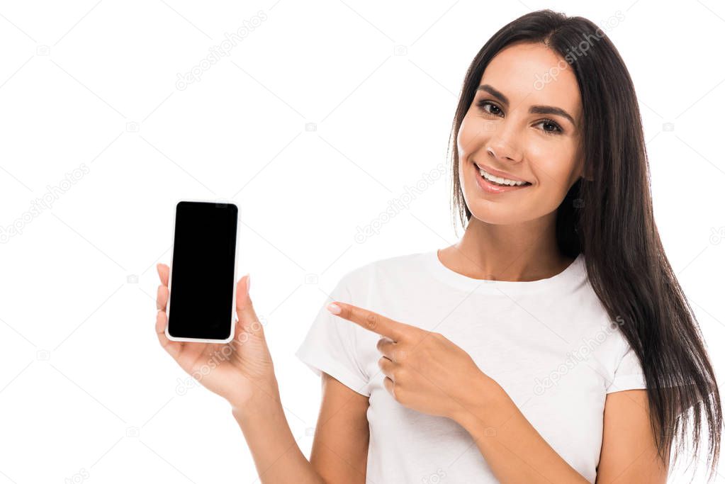 cheerful woman pointing with finger at smartphone with blank screen isolated on white 