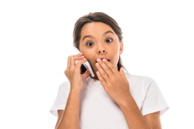 Şok olmuş çocuk akıllı telefondan konuşuyor ve beyaz ağızla izole edilmiş ağzını kapatıyor. 