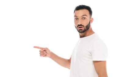Şaşırmış adam parmağıyla işaret ediyor ve beyaz kameraya bakıyor.
