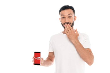 Kyiv, Ukrayna - 3 Eylül 2019: beyaz ekranda youtube uygulaması ile ağzını kapatan ve akıllı telefon tutan şaşırmış adam 