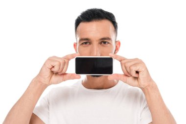 Adam kameraya bakıyor ve beyaz üzerine izole edilmiş akıllı telefonla ağzını kapatıyor. 
