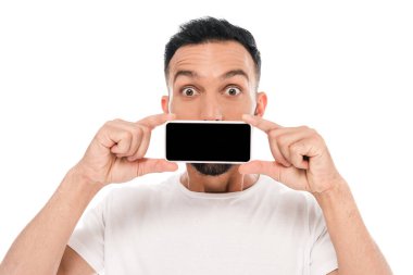Şok olmuş bir adam kameraya bakıyor ve yüzünü akıllı telefonla kapatıyor. 