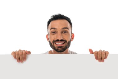 Mutlu adam beyaz pankart tutarken gülümsüyor. 