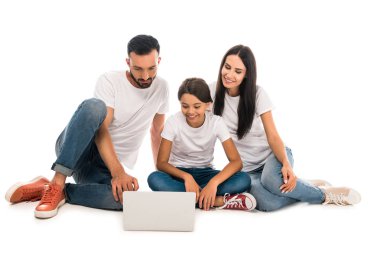 Mutlu bir aile oturup dizüstü bilgisayara bakar. 