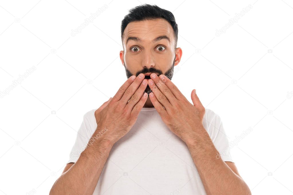 shocked and bearded man covering mouth with hands isolated on white 