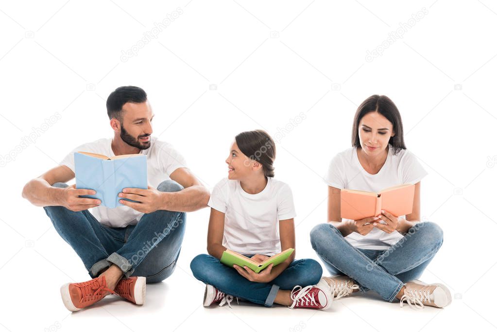 smiling family holding books while sitting isolated on white 