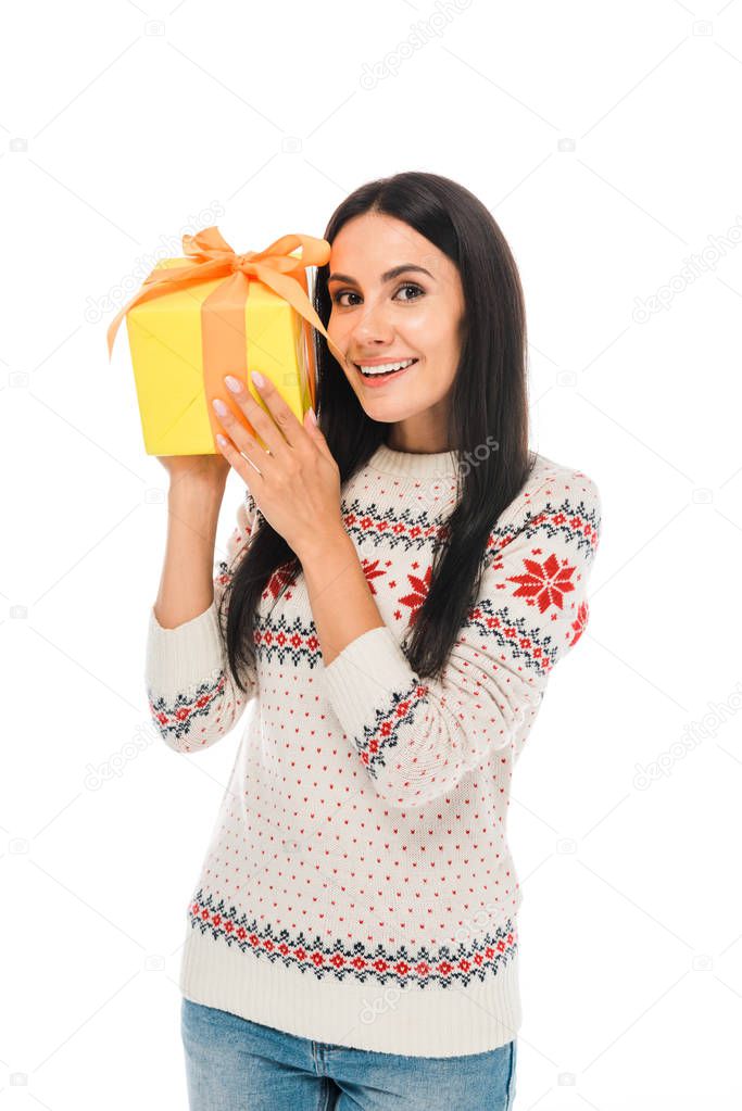 smiling woman in sweater holding gift isolated on white 