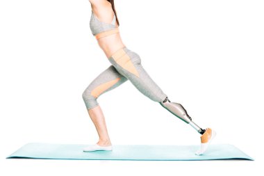 partial view of disabled sportswoman with prosthesis stretching isolated on white clipart
