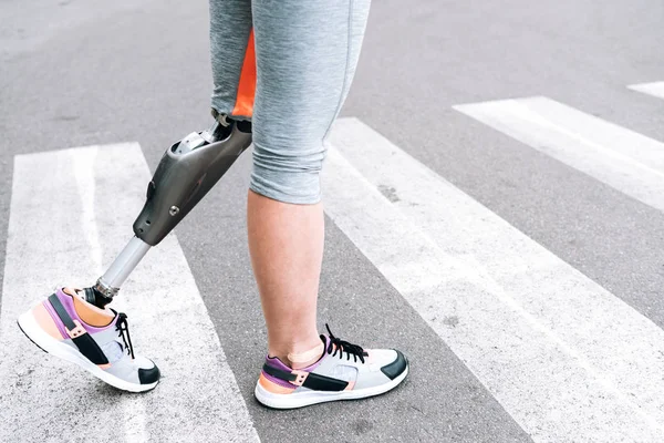 partial view of disabled woman with prosthesis on street