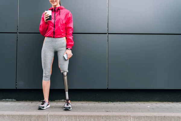 Vista Ritagliata Sorridente Sportiva Disabili Possesso Tazza Smartphone Sulla Strada — Foto Stock