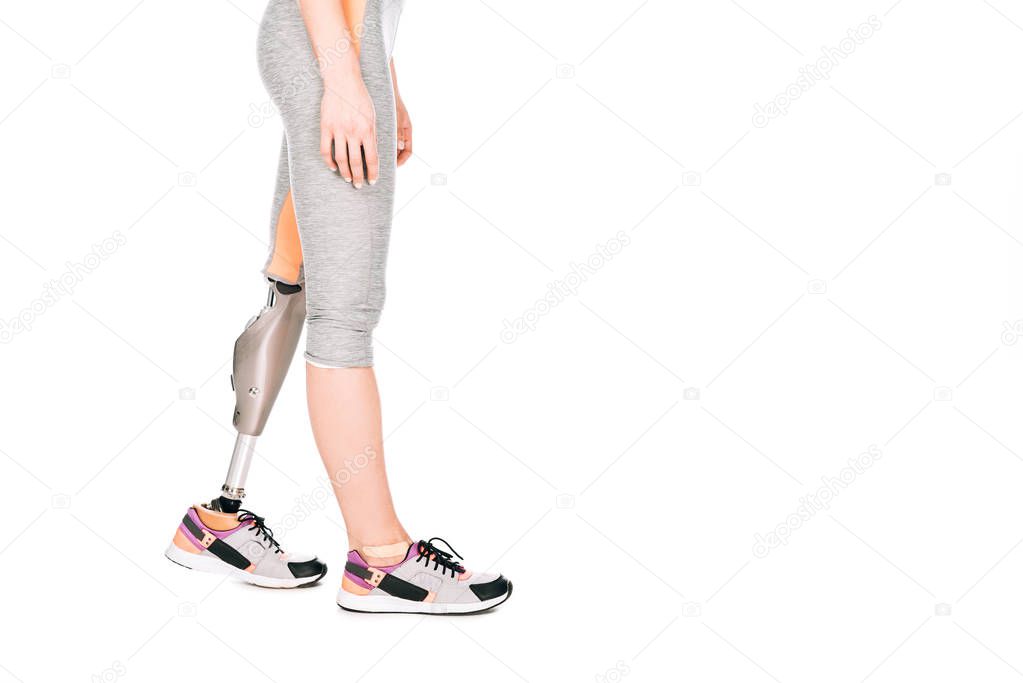 partial view of disabled sportswoman with prosthetic leg isolated on white