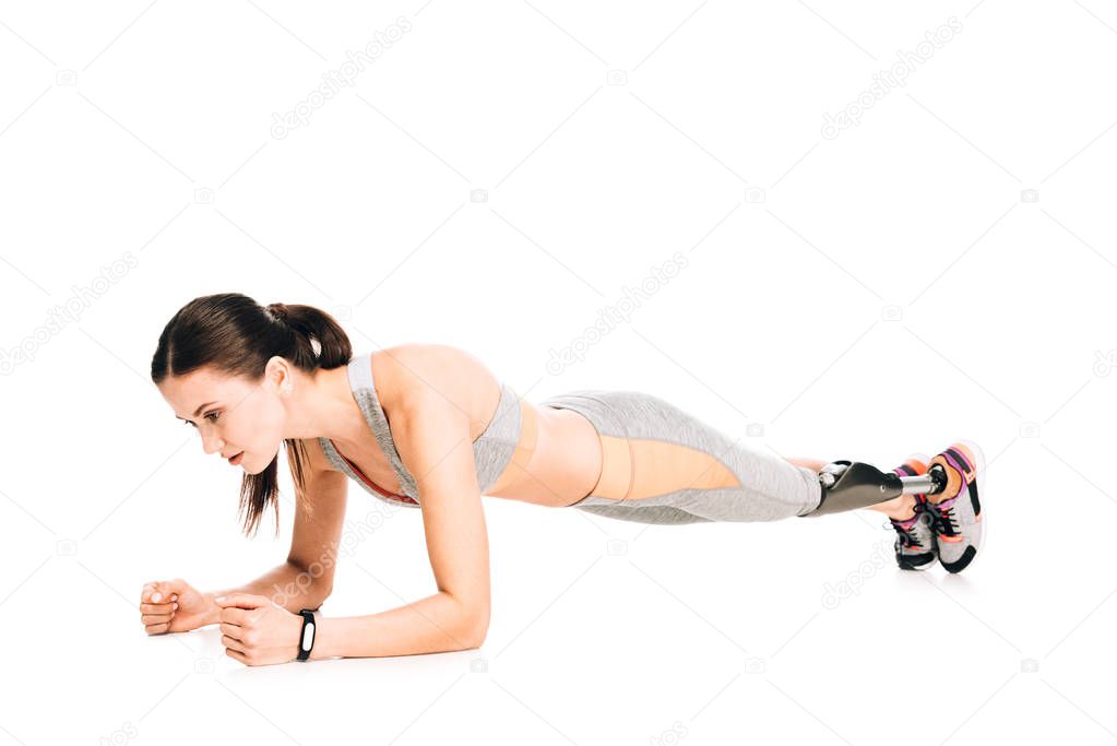 disabled sportswoman with prosthesis standing in plank isolated on white