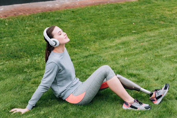 Gehandicapte Sportvrouw Zittend Gras Luisterend Naar Muziek Hoofdtelefoon — Stockfoto