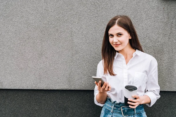 Schöne Junge Frau Mit Smartphone Und Tasse Auf Der Straße — Stockfoto