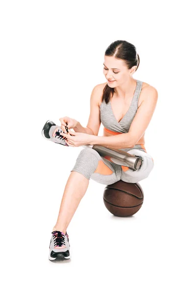 Smiling Disabled Sportswoman Prosthesis Sitting Basketball Ball Tying Shoelaces Isolated — Stock Photo, Image