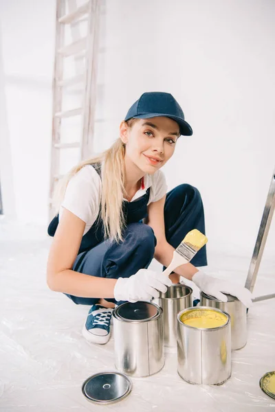 Beautiful Young Painter Overalls Cap Holding Paintbrush Can Yellow Paint — Stock Photo, Image