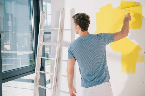 Back View Young Man Painting White Wall Yellow Paint Roller — Stock Photo, Image