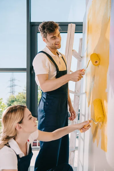 Zwei Junge Maler Malen Wand Gelb Mit Farbwalzen — Stockfoto