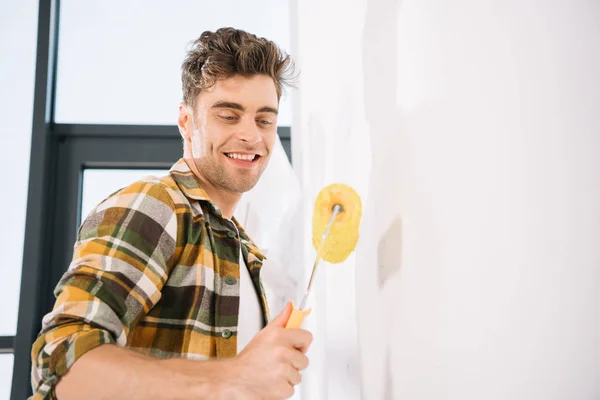 Joven Guapo Sonriendo Mientras Sostiene Rodillo Pintura Amarillo — Foto de Stock