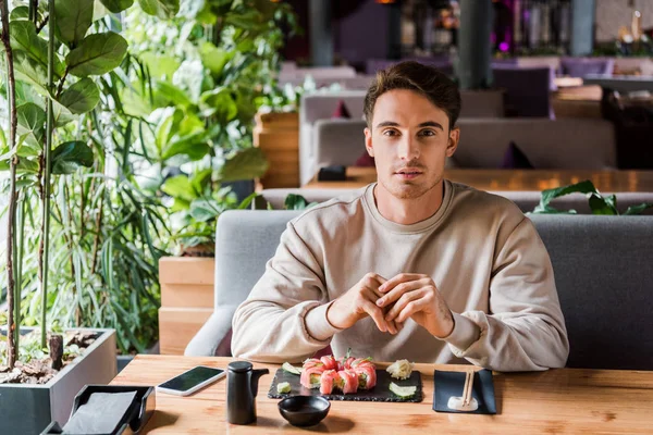 Hombre Guapo Sentado Bar Sushi Cerca Comida Sabrosa — Foto de Stock