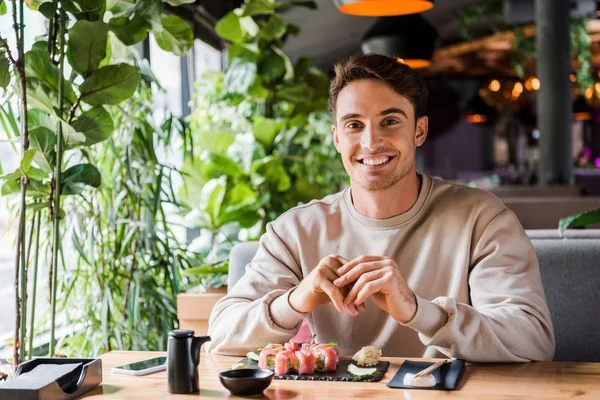 Veselý Muž Sedí Sushi Baru Blízkosti Chutného Jídla — Stock fotografie