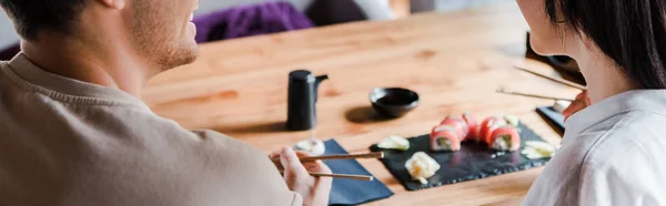 Panoramic Shot Man Holding Chopsticks Young Woman Sushi Bar — Stock Photo, Image
