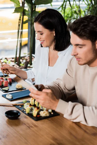 Selektivt Fokus Glad Flicka Håller Ätpinnar Nära Sushi Medan Sitter — Stockfoto