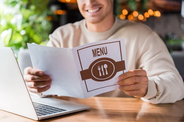 Vista Cortada Homem Feliz Segurando Menu Perto Laptop Restaurante — Fotografia de Stock