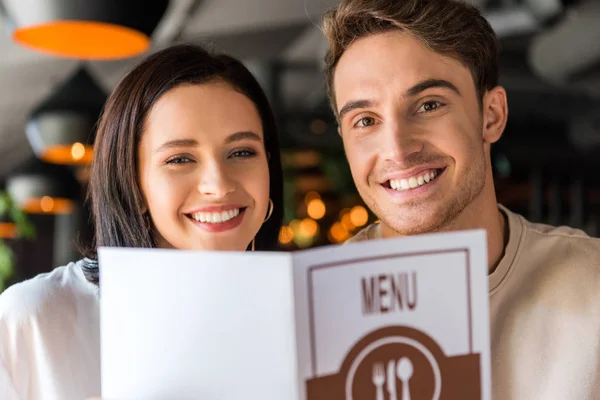 Selective focus of happy man and woman holding menu — Stock Image Selective Focus Happy Man Woman Holding Menu Stock Photo
