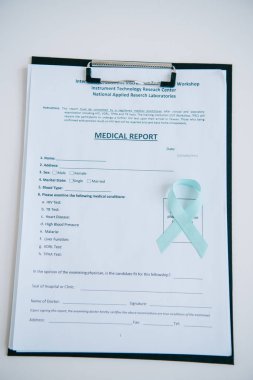 blue awareness ribbon and medical report on clipboard clipart