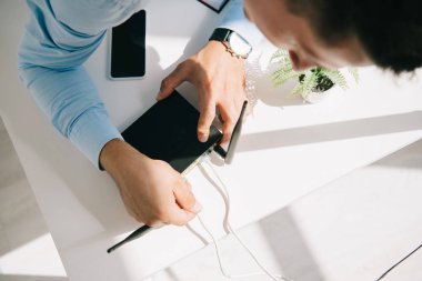 selective focus of businessman plugging router on office table clipart