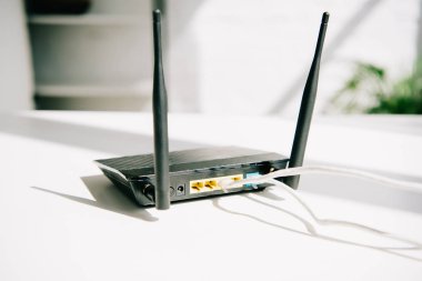 black plugged router on white office table in sunshine