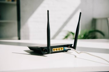 black plugged router on white office table in sunshine clipart