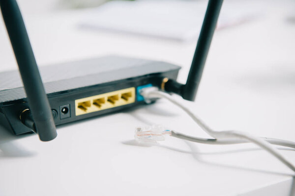 selective focus of black plugged router on office table