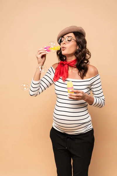 Pregnant French Woman Beret Blowing Soap Bubbles Beige Background — Stock Photo, Image