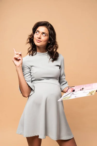 Pregnant Woman Grey Dress Holding Magazine Showing Idea Gesture Beige — Stock Photo, Image