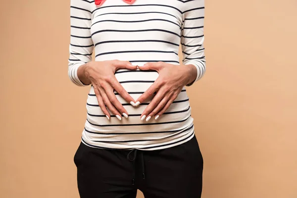Beskärd Utsikt Över Gravid Kvinna Visar Hjärttecken Beige Bakgrund — Stockfoto