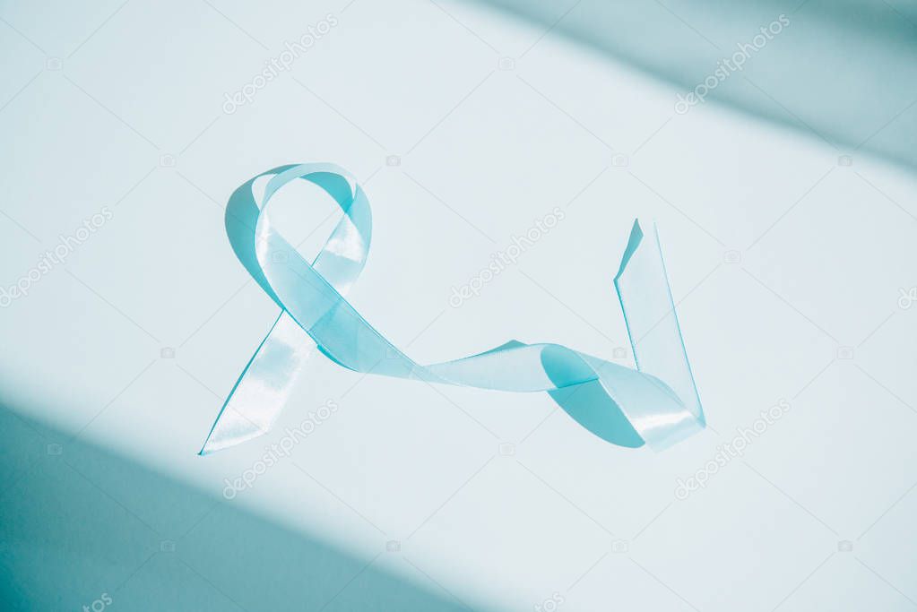 blue awareness ribbon on white background with shadows