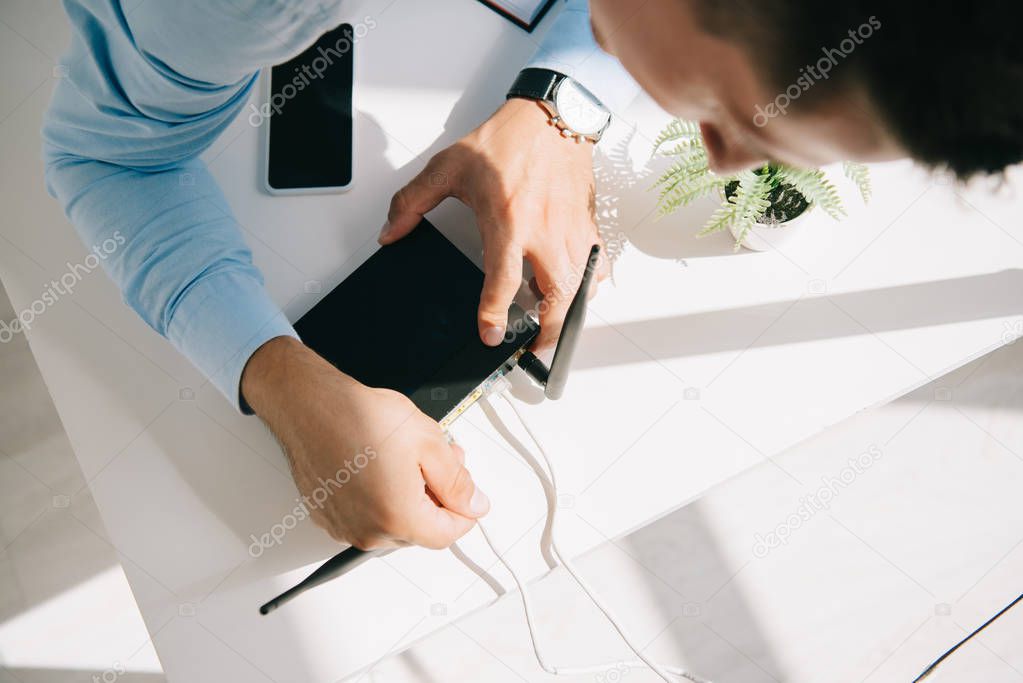 selective focus of businessman plugging router on office table