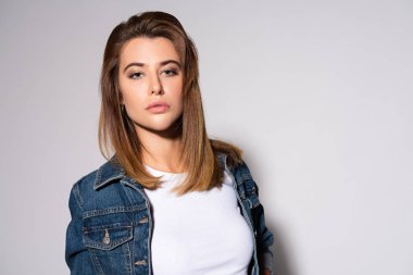 beyaz kameraya bakan çekici genç bir kadın. 