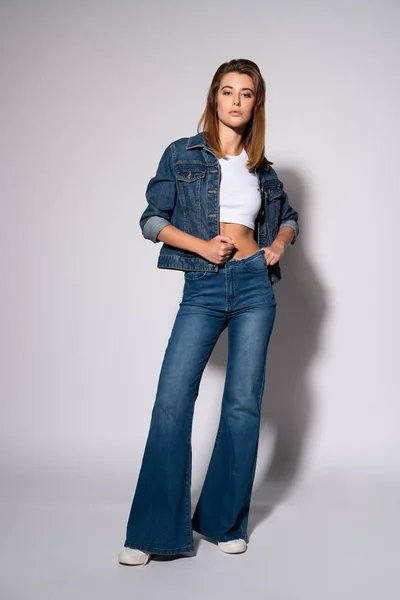 Elegante Ragazza Toccare Jeans Mentre Piedi Bianco — Foto Stock