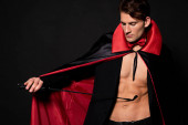 sexy Mann im Vampir-Halloween-Kostüm mit Prügelpeitsche isoliert auf schwarz 