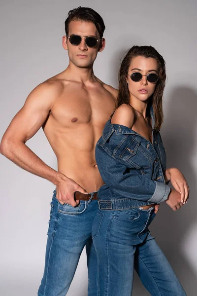 Stylish Muscular Man Sunglasses Touching Belt Girl Denim Jacket White — Stock Photo, Image