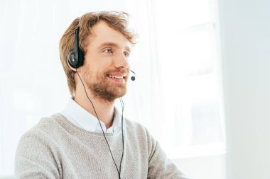 handsome bearded operator in brokers agency in headset  clipart