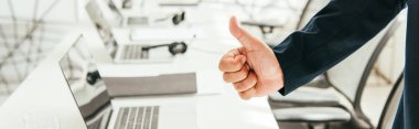 Komisyoncunun modern ofiste baş parmağını gösterdiği panoramik çekim 