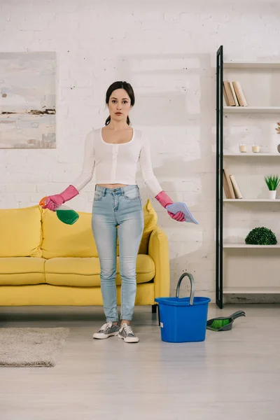 Young Attractive Housewife Holding Rag Spray Bottle While Standing Yellow — Stock Photo, Image