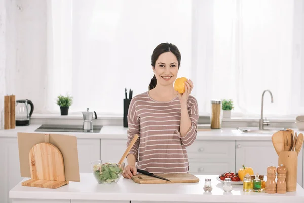 Feliz Joven Sonriendo Cámara Mientras Está Pie Mesa Cocina Sosteniendo — Foto de Stock