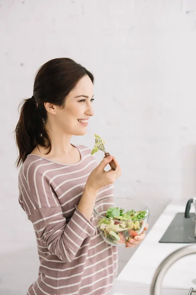 Atractiva Mujer Alegre Mirando Hacia Otro Lado Mientras Come Ensalada —  Fotos de Stock