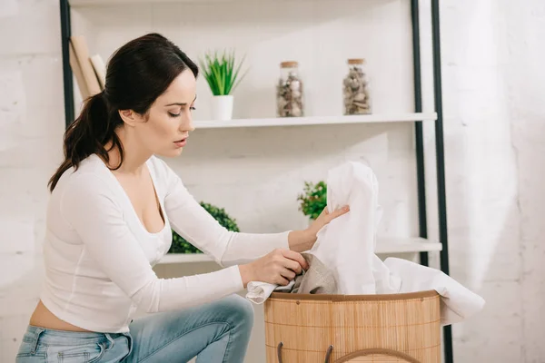 Hübsche Hausfrau Zieht Kleidung Aus Wäschekorb — Stockfoto