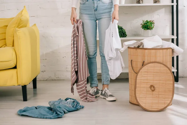 Vista Ritagliata Casalinga Jeans Denim Che Tiene Vestiti Mentre Piedi — Foto Stock